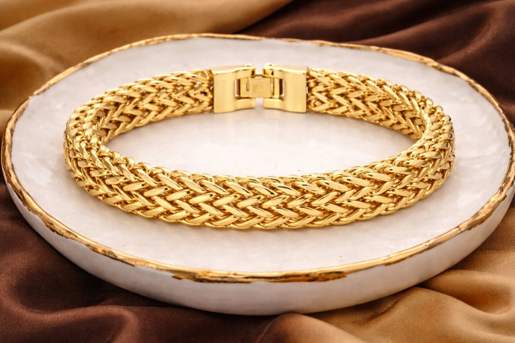 Gold bracelet on a white dish with a brown fabric background