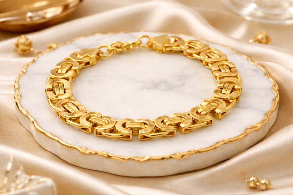 Gold bracelet on a marble surface with a soft beige background