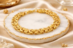 Gold bracelet on a marble surface with a soft beige background