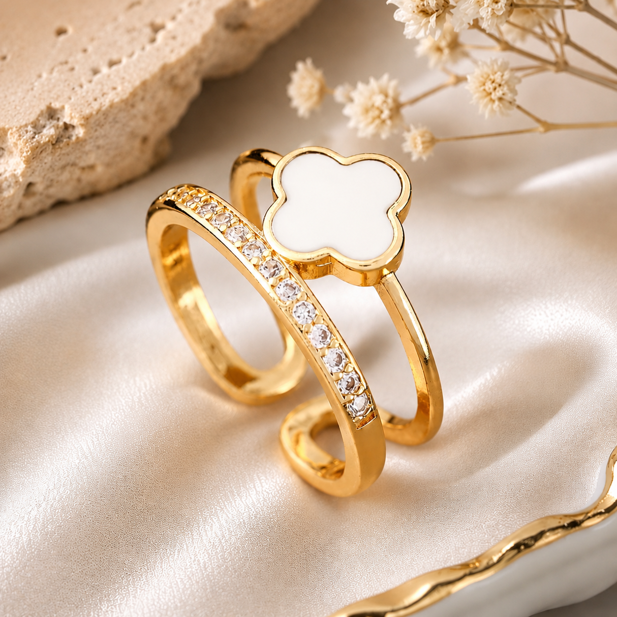 Anti Tarnish ring with a white clover-shaped center on a beige fabric background
