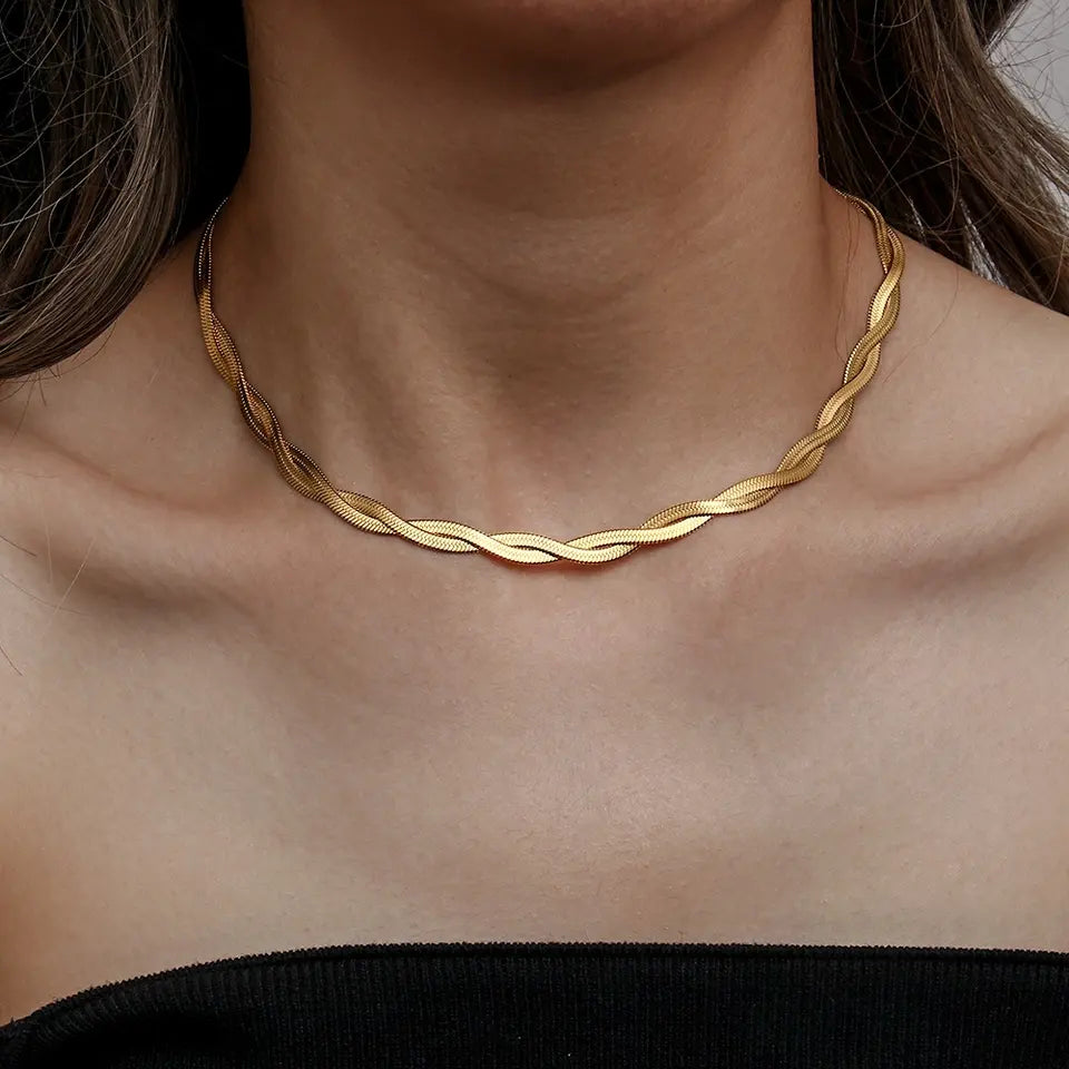 Gold necklace on a person's neck with a blurred background