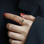 Close-up of a hand wearing Emerald with gemstones against a dark background