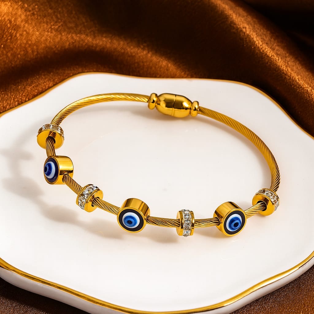 Gold bracelet with evil eye charm and AD stones on it