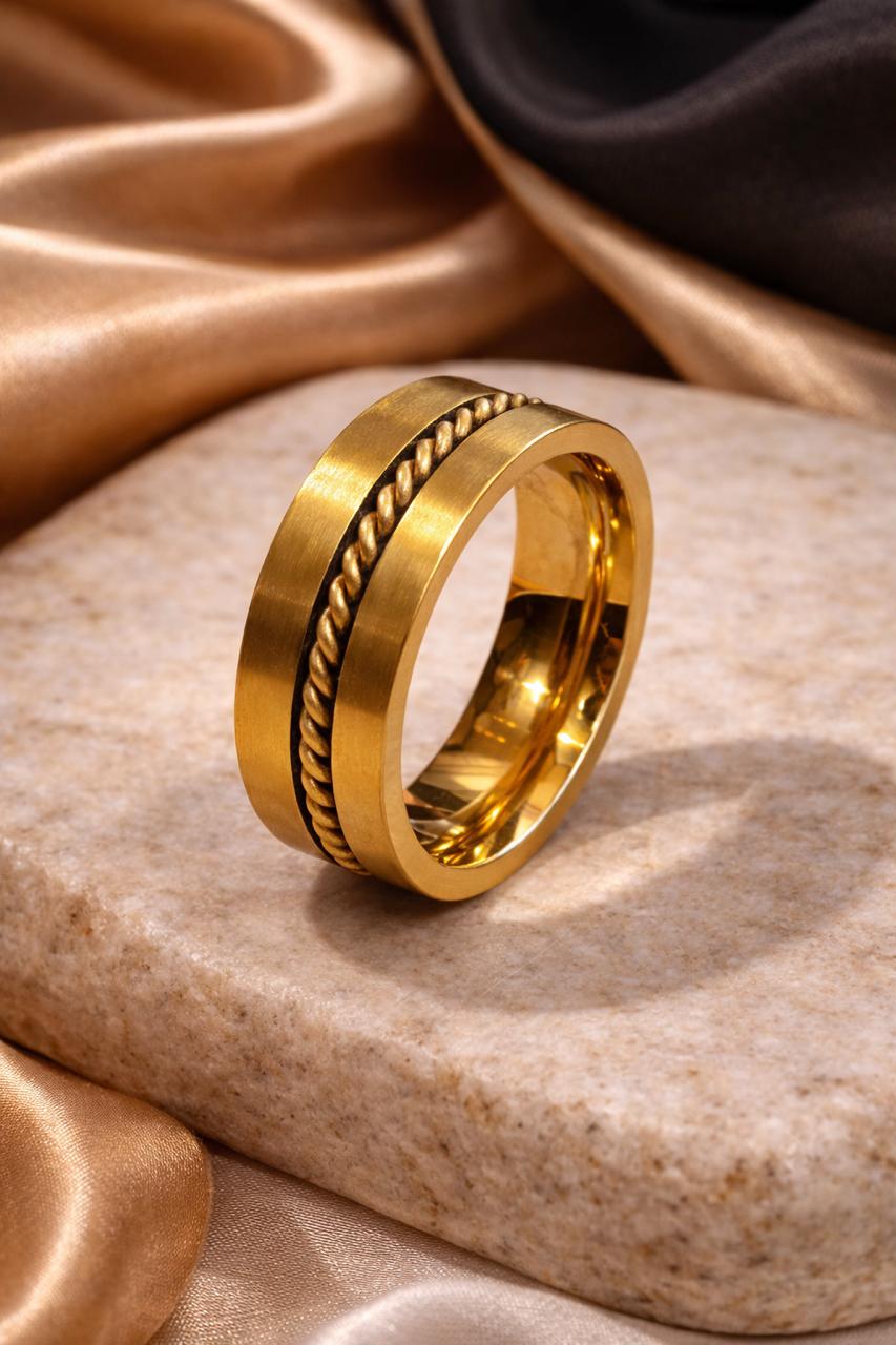 Gold ring with textured design on a stone surface