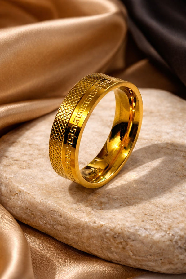 Gold plated ring with textured design on a stone surface