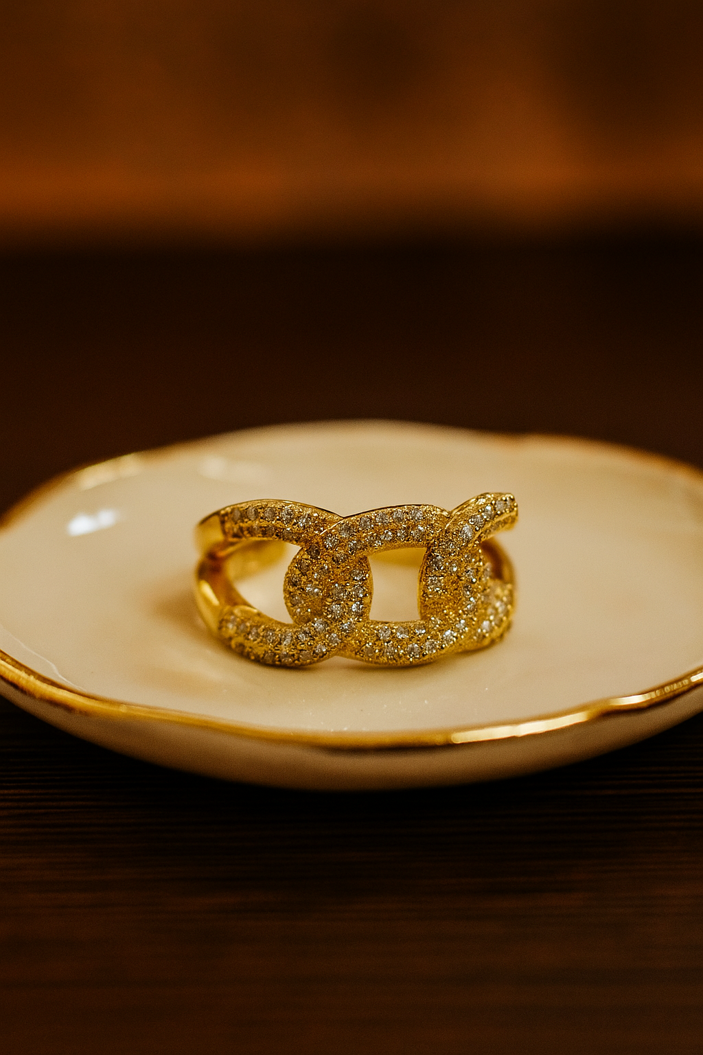 Gold chain ring on a white dish with a brown background