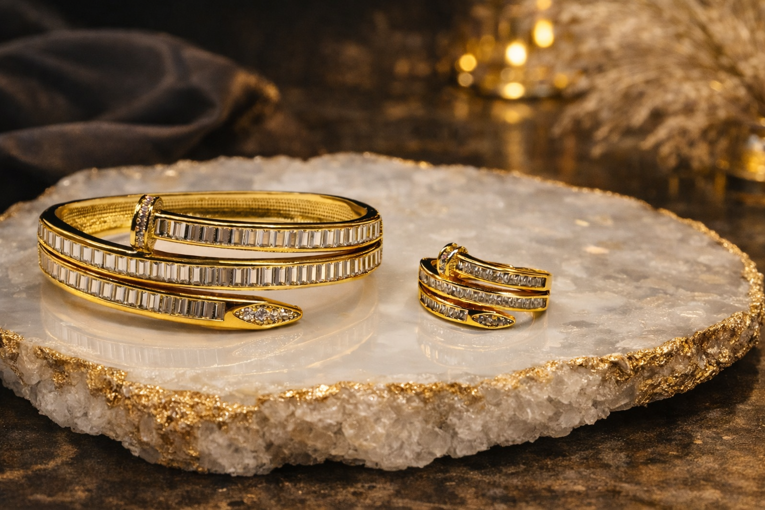 Gold nail bracelet and ring on a decorative stone surface with soft lighting