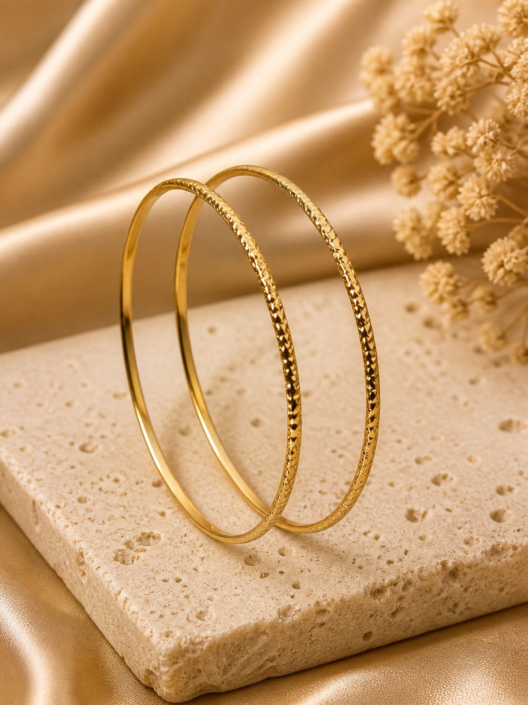 Anti Tarnish golden bangles on a textured stone surface with a beige fabric background