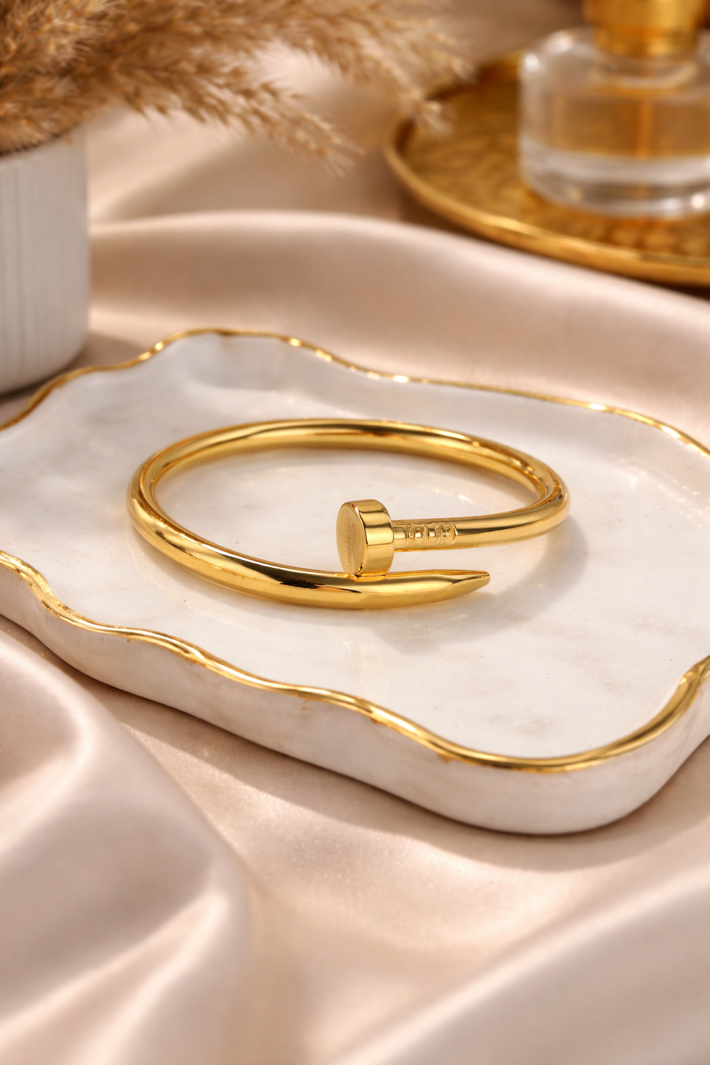 Gold bracelet on a white dish with a neutral background