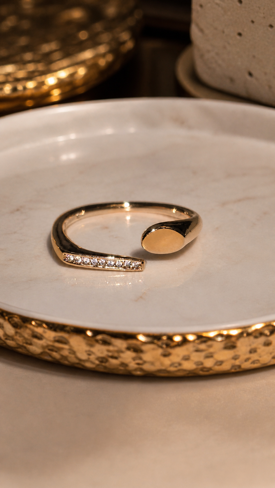 Gold ring with small diamonds on a textured white surface