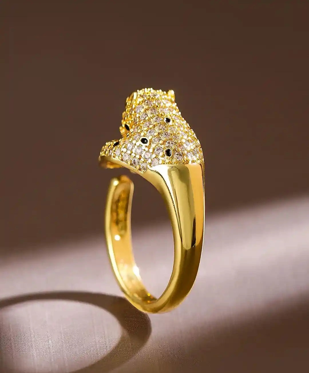 Gold panther back head ring on a brown background