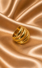 Gold ring on a textured gold fabric background - Quadra Finger Ring