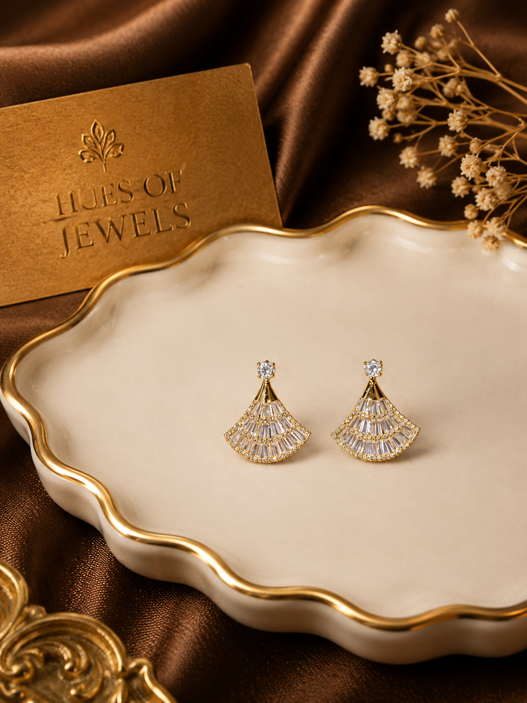 Anti tarnish earrings on a decorative dish with 'Hues of Jewels' card in the background
