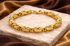 Gold bracelet on a stone surface with a brown fabric background