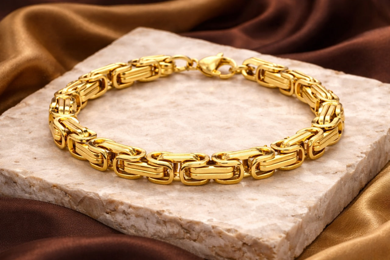Gold bracelet on a stone surface with a brown fabric background