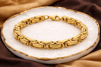 Gold bracelet on a white dish with brown fabric background