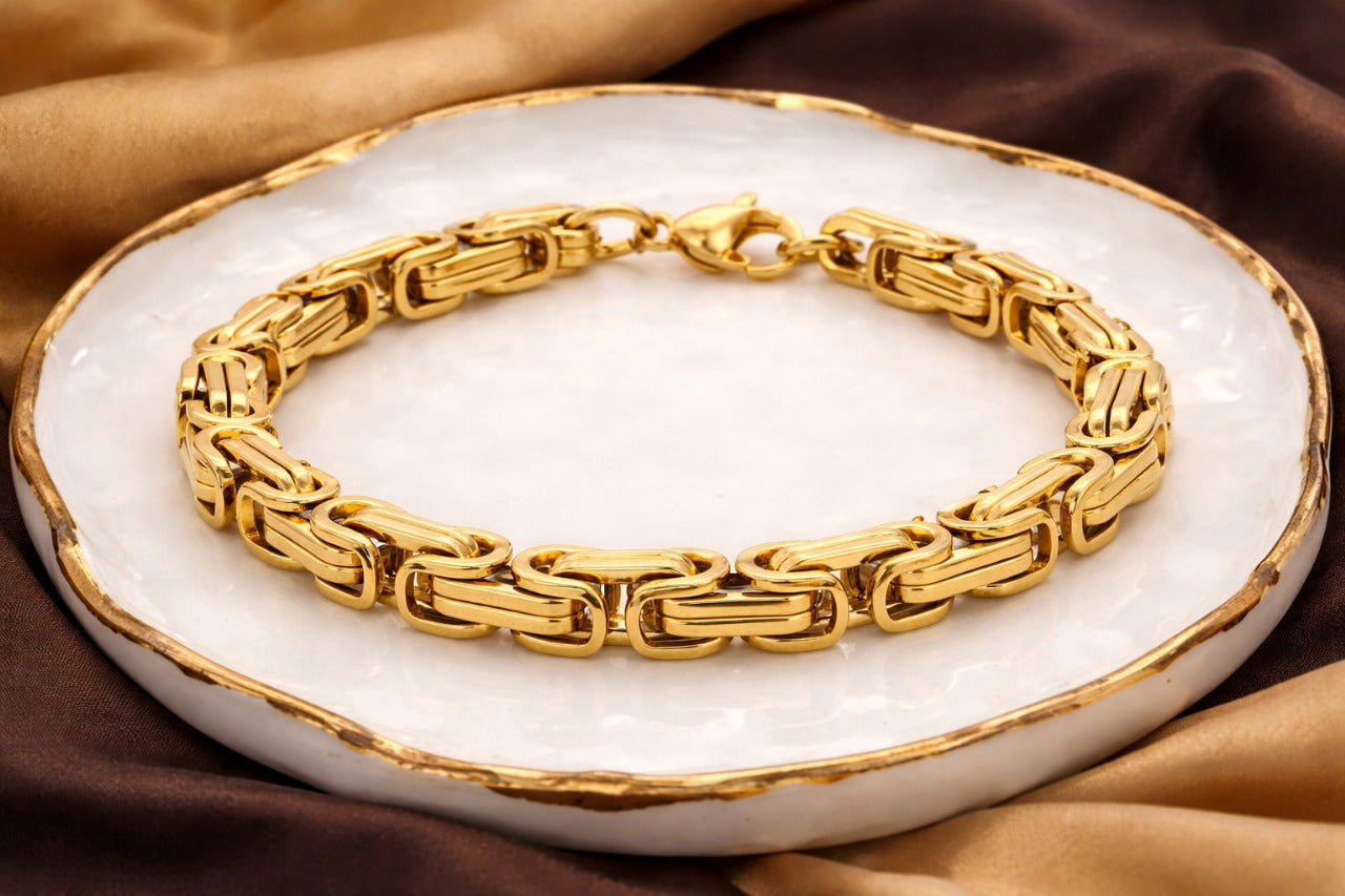Gold bracelet on a white dish with brown fabric background