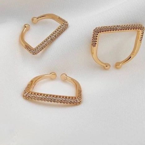 Gold square shaped ring with diamond-like stones on a white background