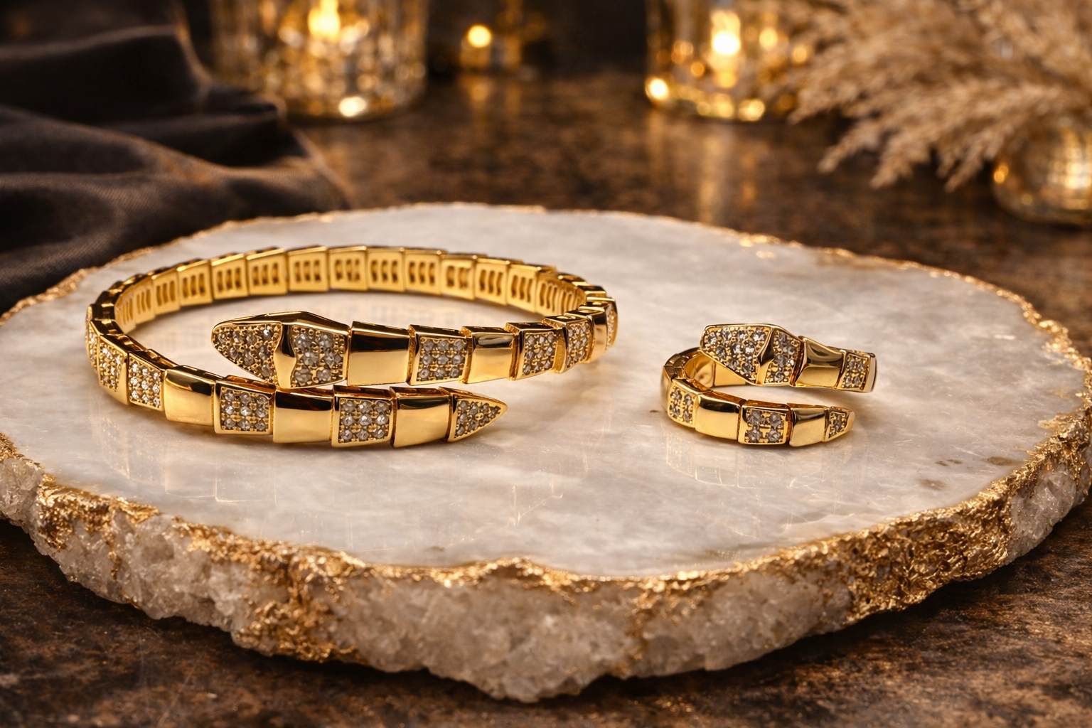 Gold bracelet and ring set on a marble surface with decorative background
