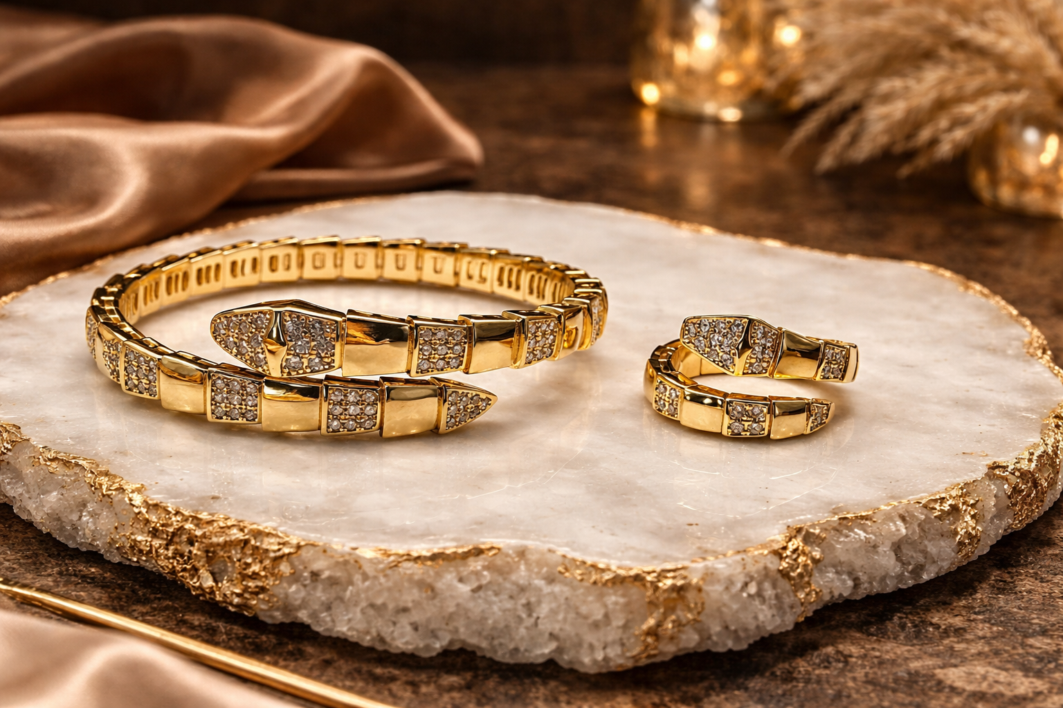 Gold snake bracelet and ring set on a decorative stone surface with soft lighting.