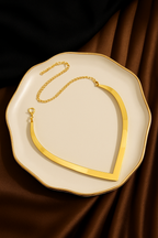Gold Plated Choker necklace on a decorative plate with a brown fabric background